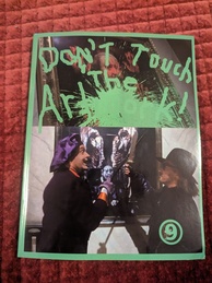 9front DON'T TOUCH THE ARTWORK manual. Upper half features a painting with green splatters and 'Don't touch the artwork' in a green a finger-paint-like scrawl. The bottom half shows two characters, one dressed as an artist wearing purple preventing another character from using a large knife to damage a painting.