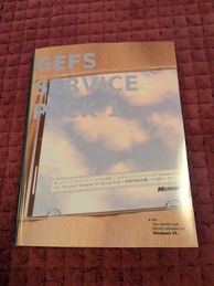 9 Front manual showing an open CD jewel case on a tabletop. The inside of the liner shows a blue sky with clouds and some Japanese text with the English words Microsoft Windows 95 Service Pack 1 included. There is a note in the corner of the cover that says
