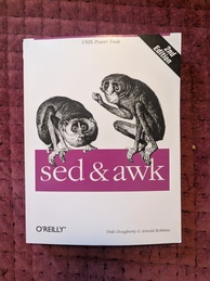 sed & awk cover. Features two slender lorises posing on the words 'sed' and 'awk' as if that's their names